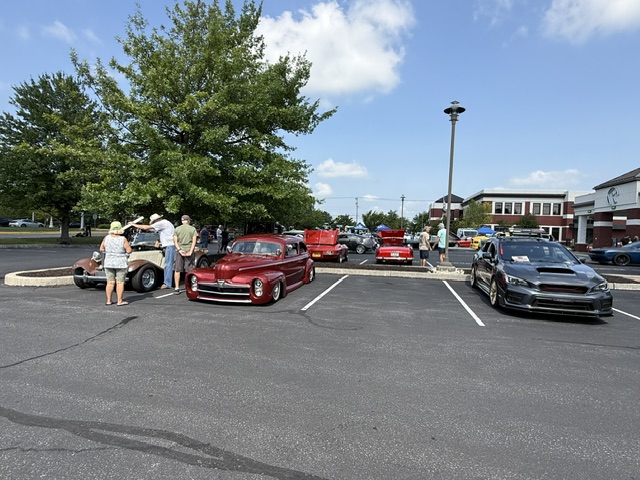 People walking around custom vehicles at Cars and Coffee in Wyomissing Pennsylvania.