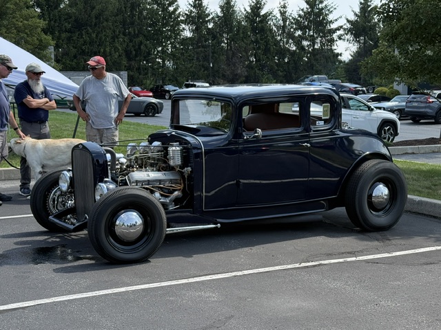 Black hot rod with exposed engine at Cars and Coffee in Wyomissing Pennsylvania.