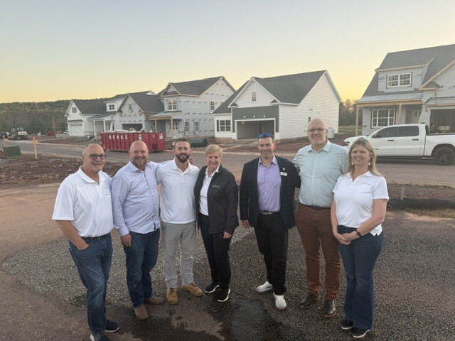 Scottish Hollow project representatives standing in front of new homes under construction in Amity Township.